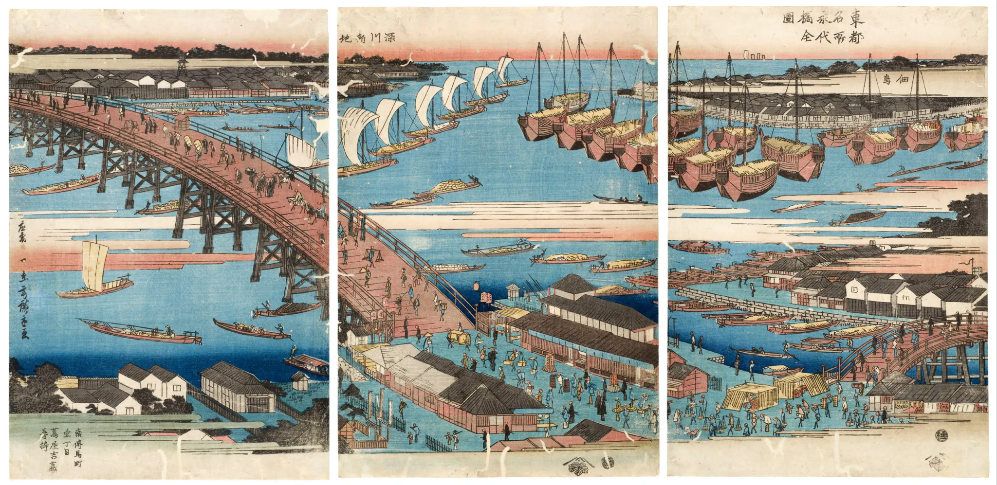 A wide three-panel color woodblock-style harbor scene shows a large wooden bridge crossing blue water, numerous traditional sailing and rowing boats, waterfront warehouses and docks, and many small pedestrians moving along the bridge and shore. The image has a calm, densely populated urban waterfront atmosphere with pale blue water, red-pink sky bands, dark roofs, and extensive Japanese calligraphy.